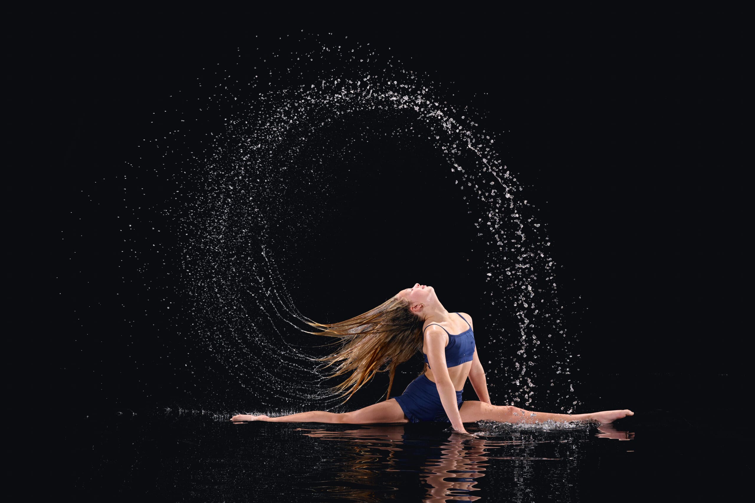 Dancer photographed during an indoor rain session with dramatic studio lighting<br />
